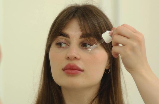 woman putting on eye drops